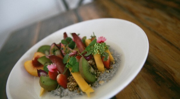 Organic chia pudding topped with rawnola and served with nut mylk at Greenhouse Factory, Kirra